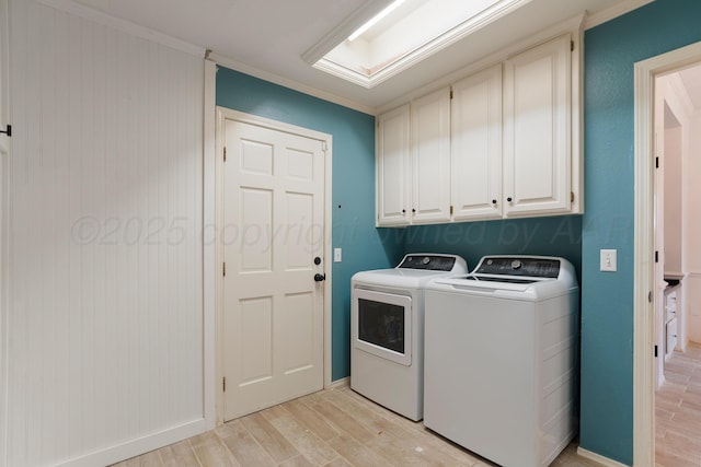 laundry area with light wood finished floors, separate washer and dryer, cabinet space, and crown molding