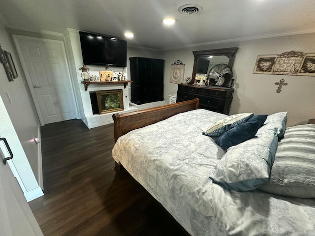 219 Inverness St, Borger, TX 79007 - bedroom featuring dark wood-style flooring, a brick fireplace, and crown molding