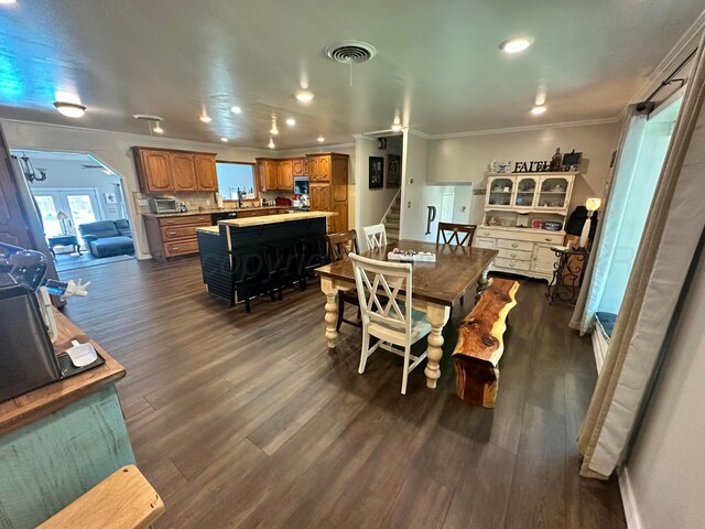 219 Inverness St, Borger, TX 79007 - dining space featuring crown molding, stairway, dark wood-type flooring, arched walkways, and recessed lighting