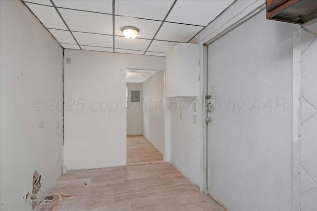 corridor with a paneled ceiling and electric panel