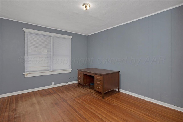 interior space featuring ornamental molding, baseboards, and wood finished floors