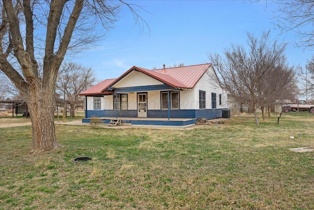 view of front of property with metal roof, a porch, a front yard, and cooling unit