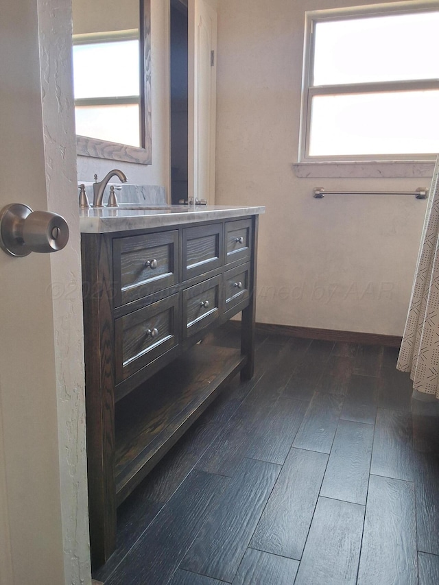 full bathroom with plenty of natural light, vanity, and wood finished floors