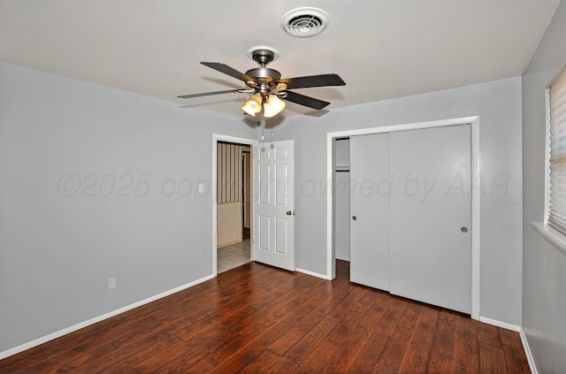 unfurnished bedroom featuring wood finished floors, baseboards, a closet, and a ceiling fan