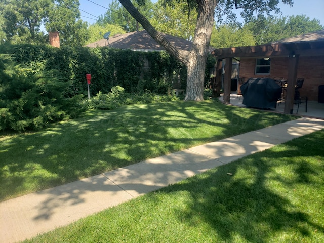 view of grassy yard with a pergola and a patio