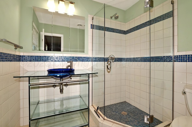 bathroom featuring toilet, a shower stall, and a sink