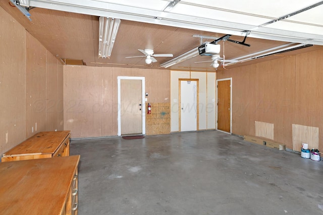 garage with a garage door opener and wood walls