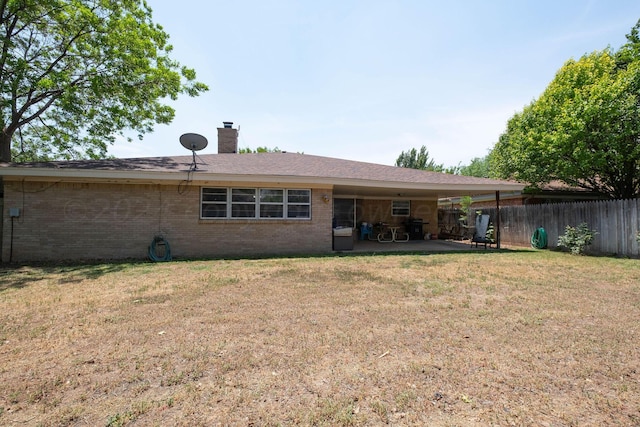 rear view of house featuring a yard and a patio area