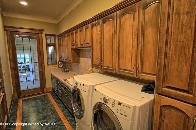 washroom featuring ornamental molding, cabinets, and separate washer and dryer