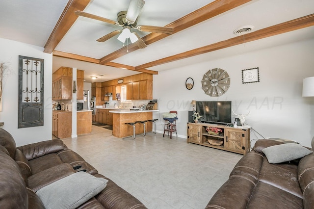 living room with beamed ceiling and ceiling fan