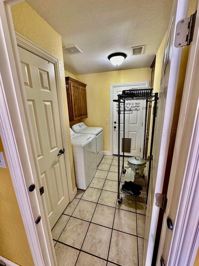 8422 Addison Dr, Amarillo, TX 79119 - laundry area with separate washer and dryer, cabinet space, light tile patterned floors, a textured ceiling, and a textured wall
