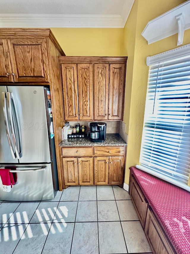 8422 Addison Dr, Amarillo, TX 79119 - kitchen featuring freestanding refrigerator, brown cabinets, crown molding, and light tile patterned floors