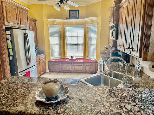 8422 Addison Dr, Amarillo, TX 79119 - kitchen with crown molding, stainless steel appliances, dark countertops, light tile patterned floors, and a ceiling fan