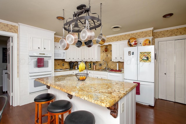 3 Nottingham Rd, Amarillo, TX 79124 - kitchen with white appliances, dark wood finished floors, white cabinetry, a sink, and crown molding