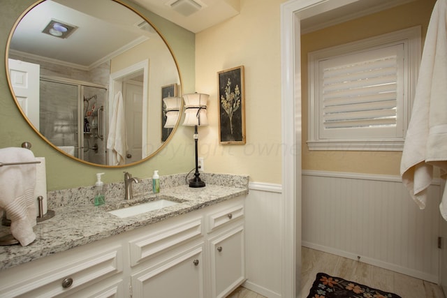 3 Nottingham Rd, Amarillo, TX 79124 - bathroom featuring ornamental molding, a shower stall, wood finished floors, vanity, and a wainscoted wall