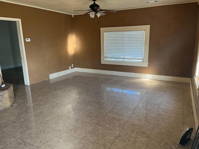 tiled empty room featuring ceiling fan and ornamental molding