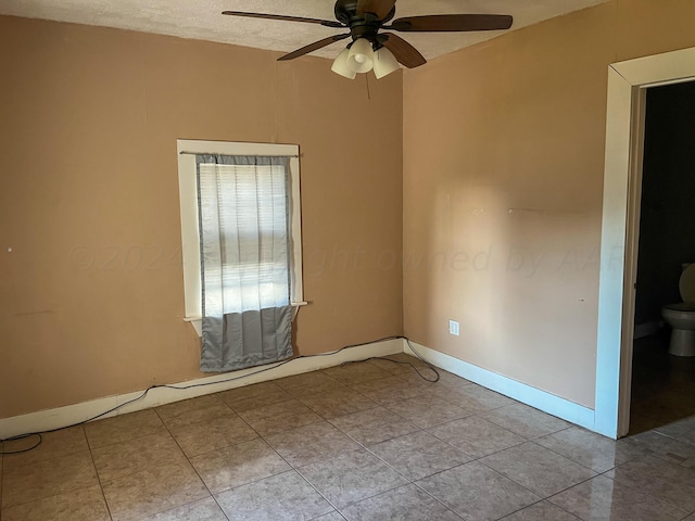 tiled spare room featuring ceiling fan and a textured ceiling