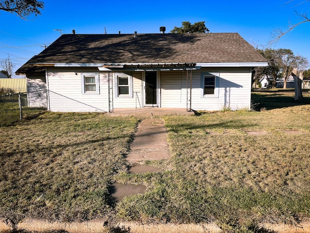 rear view of property featuring a lawn