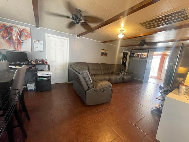 living room featuring beamed ceiling, dark tile patterned floors, and ceiling fan