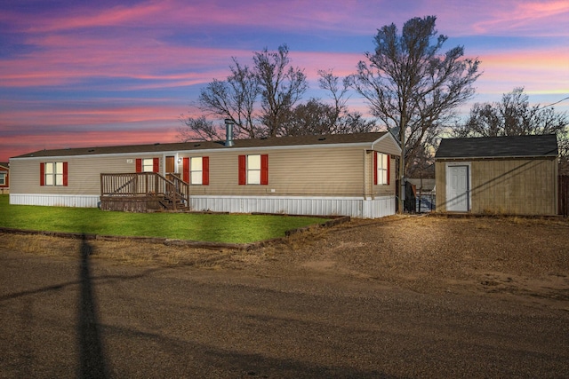 manufactured / mobile home featuring a yard and a shed