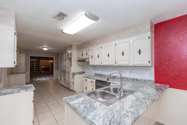 2709 Mohawk Dr, Amarillo, TX 79109 - kitchen featuring a sink, light countertops, a peninsula, white cabinets, and a wainscoted wall