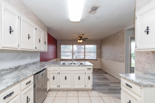 2709 Mohawk Dr, Amarillo, TX 79109 - kitchen with stainless steel dishwasher, a sink, a peninsula, ceiling fan, and white cabinetry