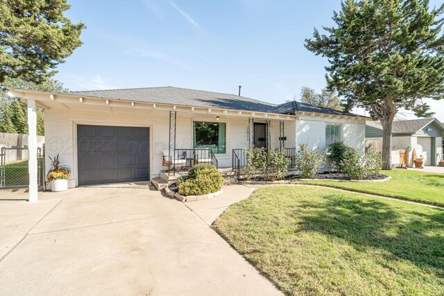 single story home with a front lawn, a garage, and covered porch