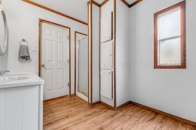 full bathroom with crown molding, a shower stall, vanity, and wood finished floors