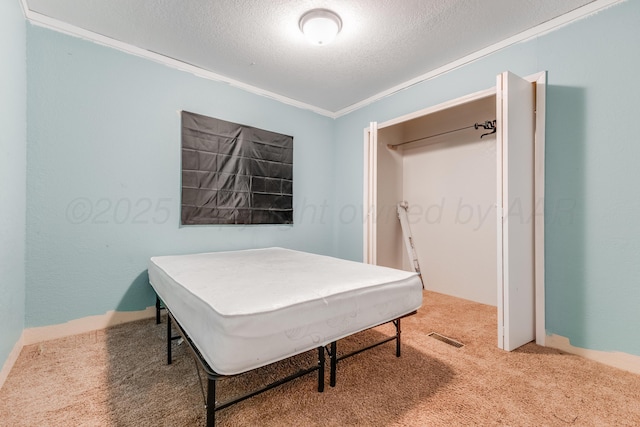 carpeted office space with a textured ceiling, visible vents, and crown molding