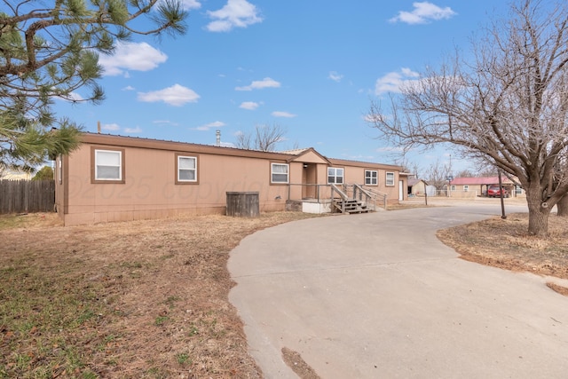 manufactured / mobile home with fence and concrete driveway