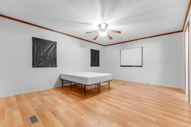 rec room with crown molding, visible vents, and wood finished floors