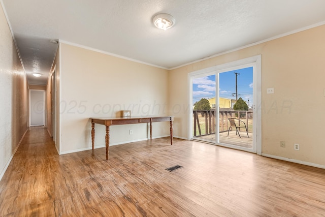 unfurnished room with ornamental molding, visible vents, and wood finished floors