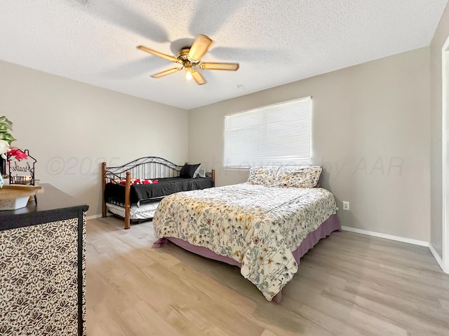 1620 Takewell St, Borger, TX 79007 - bedroom with light wood-style floors, baseboards, ceiling fan, and a textured ceiling