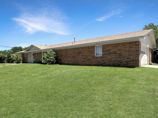 1620 Takewell St, Borger, TX 79007 - view of side of property with an attached garage, brick siding, a yard, and roof with shingles