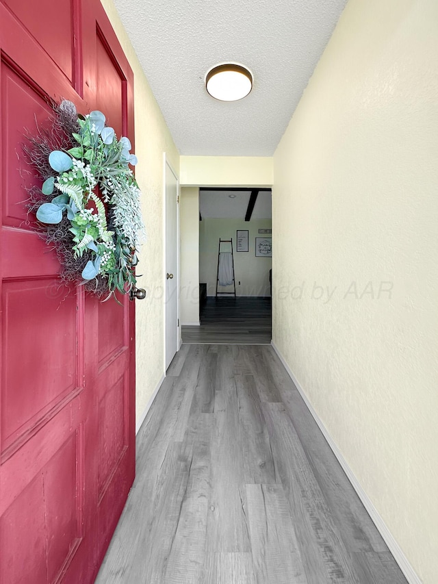 1620 Takewell St, Borger, TX 79007 - corridor with wood finished floors, baseboards, a textured ceiling, and a textured wall
