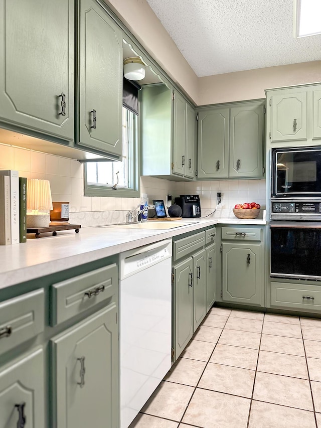 1620 Takewell St, Borger, TX 79007 - kitchen featuring black appliances, green cabinets, light countertops, and a textured ceiling