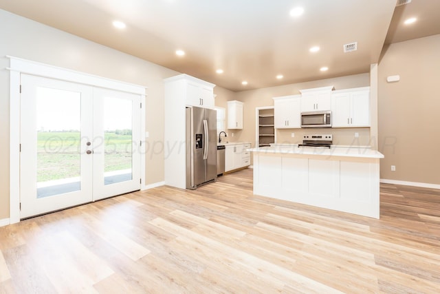 30 Country Club Dr, Farwell, TX 79325 - kitchen featuring a sink, stainless steel appliances, white cabinetry, light countertops, and light wood-style floors