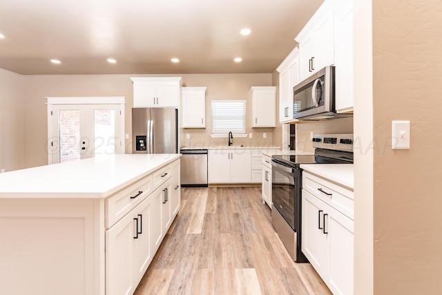 30 Country Club Dr, Farwell, TX 79325 - kitchen featuring a sink, light wood-style flooring, white cabinetry, a center island, and appliances with stainless steel finishes