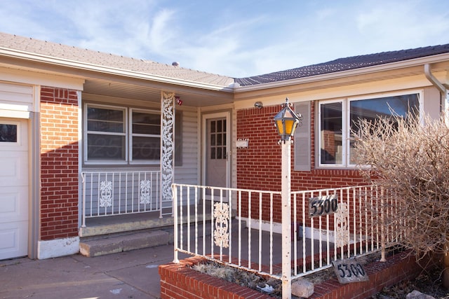 property entrance featuring brick siding and an attached garage