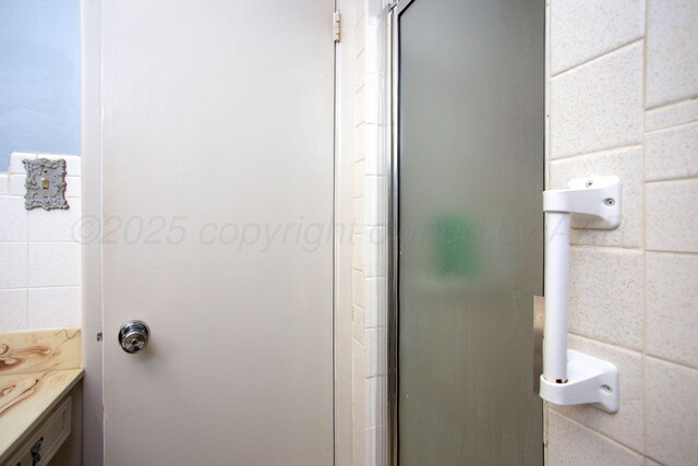 3607 Julie Dr, Amarillo, TX 79109 - bathroom with tile walls, a stall shower, and vanity