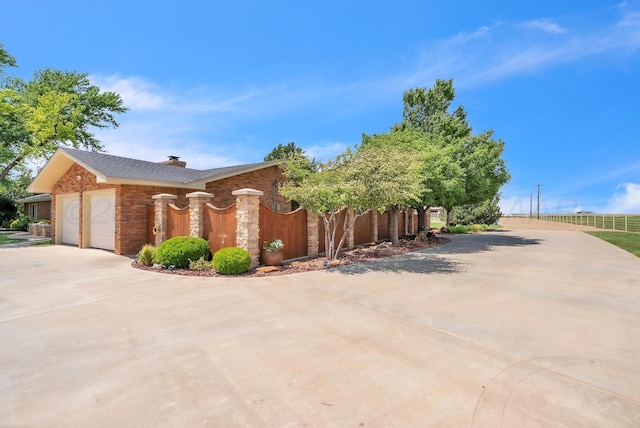 3465 Fm 1058, Hereford, TX 79045 - view of front of property with concrete driveway, an attached garage, brick siding, and a chimney