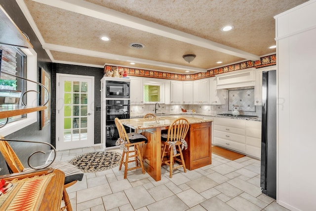 3465 Fm 1058, Hereford, TX 79045 - kitchen featuring black appliances, a sink, a textured ceiling, white cabinetry, and light stone counters