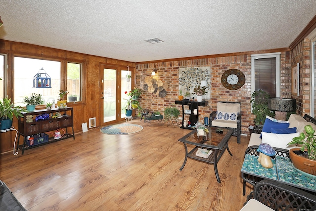 3508 Reeder Dr, Amarillo, TX 79121 - living room featuring visible vents, brick wall, wood finished floors, and a textured ceiling