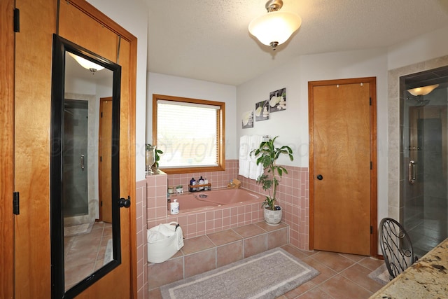 3508 Reeder Dr, Amarillo, TX 79121 - full bath featuring a garden tub, a shower stall, a textured ceiling, tile patterned flooring, and tile walls