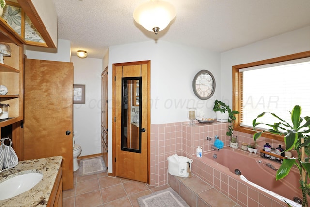 3508 Reeder Dr, Amarillo, TX 79121 - full bath with vanity, tile patterned floors, a textured ceiling, toilet, and a tub with jets