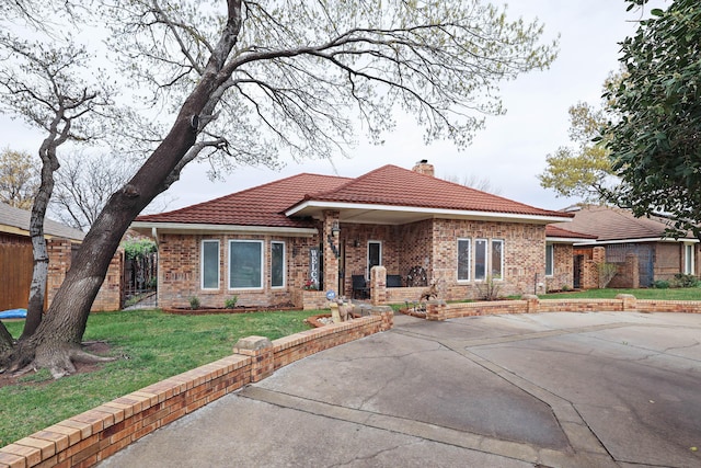 3508 Reeder Dr, Amarillo, TX 79121 - view of front of property featuring a chimney, a tile roof, brick siding, a front lawn, and driveway