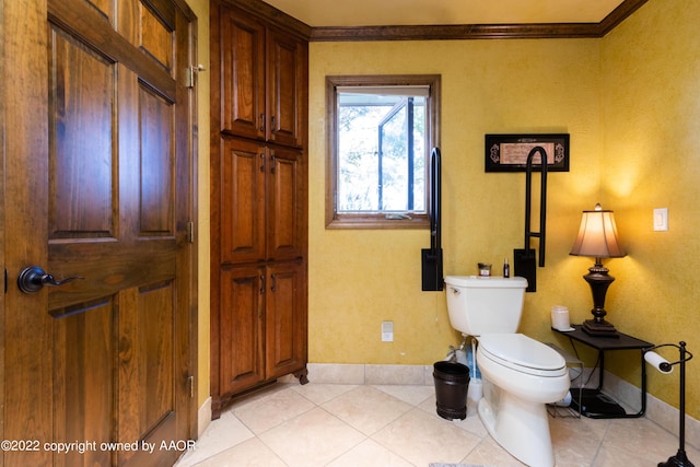 bathroom featuring tile patterned flooring, ornamental molding, and toilet