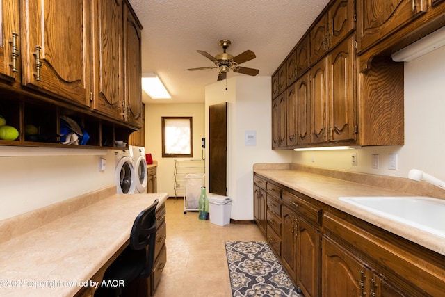 laundry room with sink, washer and clothes dryer, ceiling fan, cabinets, and a textured ceiling