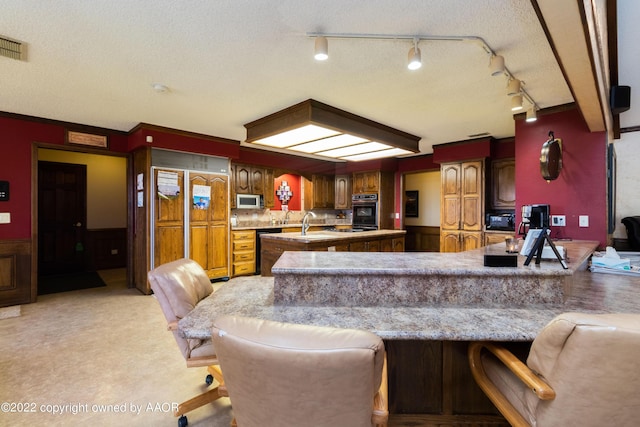 kitchen with a breakfast bar, kitchen peninsula, and black appliances