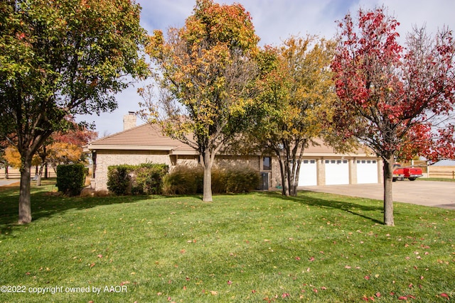 obstructed view of property featuring a garage and a front yard